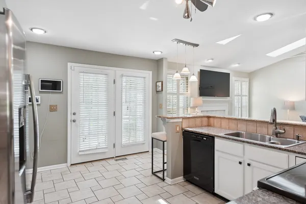 a kitchen with stainless steel appliances granite countertop a sink and a refrigerator