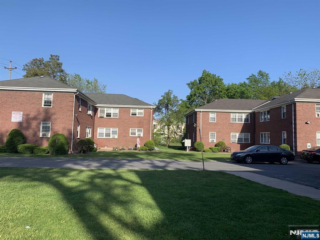 171-183 Fort Lee Road, Unit 1731C Teaneck, NJ 07666 - Photo 2 of 15 a front view of a house with a yard and garage