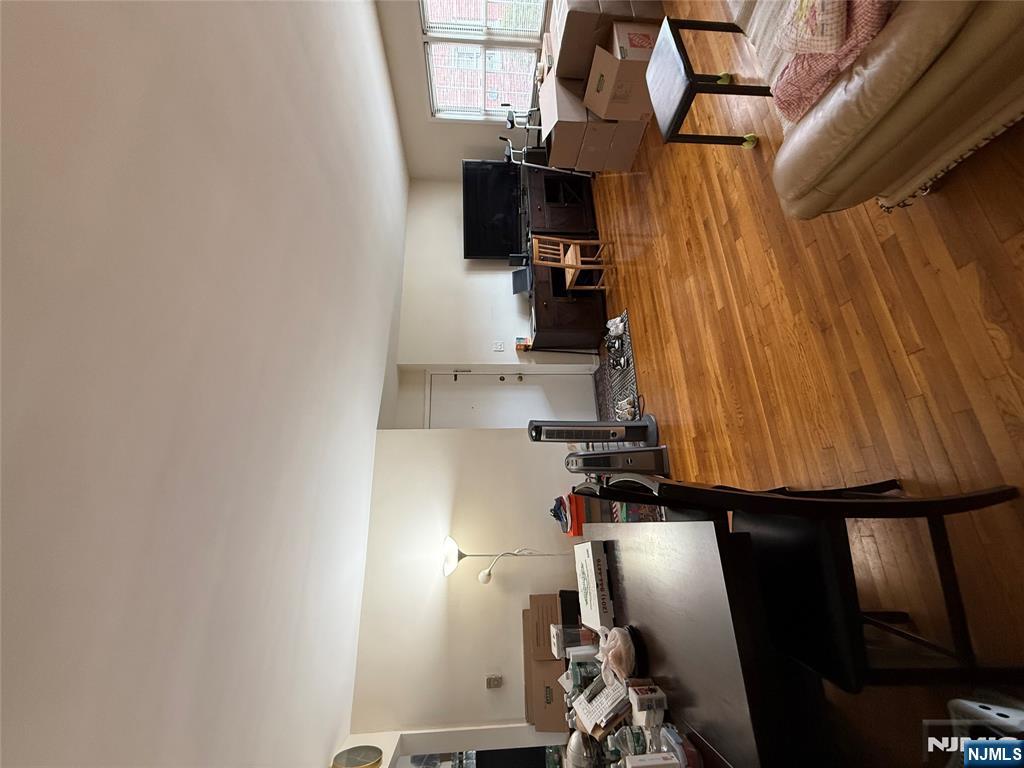 171-183 Fort Lee Road, Unit 1731C Teaneck, NJ 07666 - Photo 7 of 15 a living room with furniture and a dining table with wooden floor