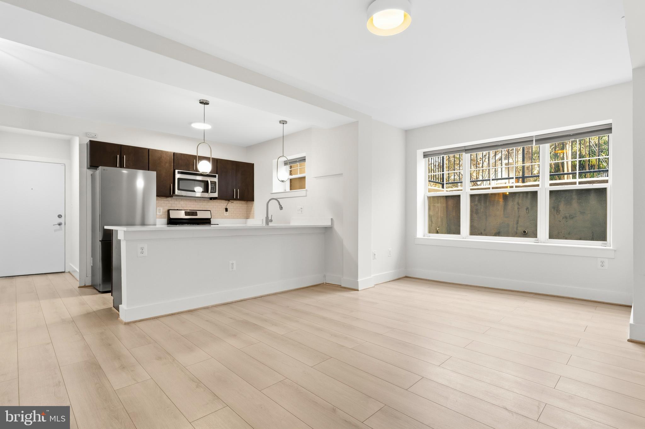 4226 7th Street Northwest, Unit 101 Washington, DC 20011 - Photo 11 of 23 a view of kitchen with stainless steel appliances wooden floor and window