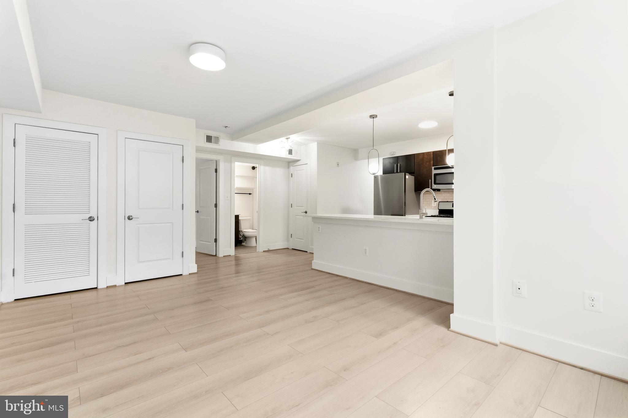 4226 7th Street Northwest, Unit 101 Washington, DC 20011 - Photo 15 of 23 a view of a livingroom with a kitchen counter space and wooden floor