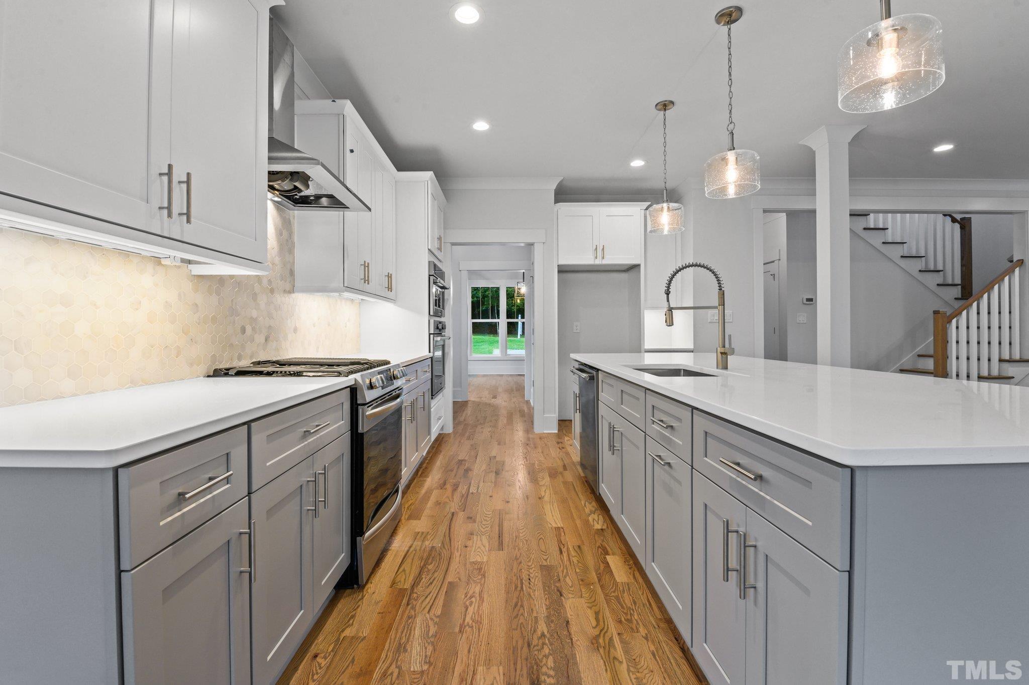 1019 Glascock Street Raleigh, NC 27610 - Photo 11 of 30 a large kitchen with stainless steel appliances kitchen island a large counter space a sink and cabinets