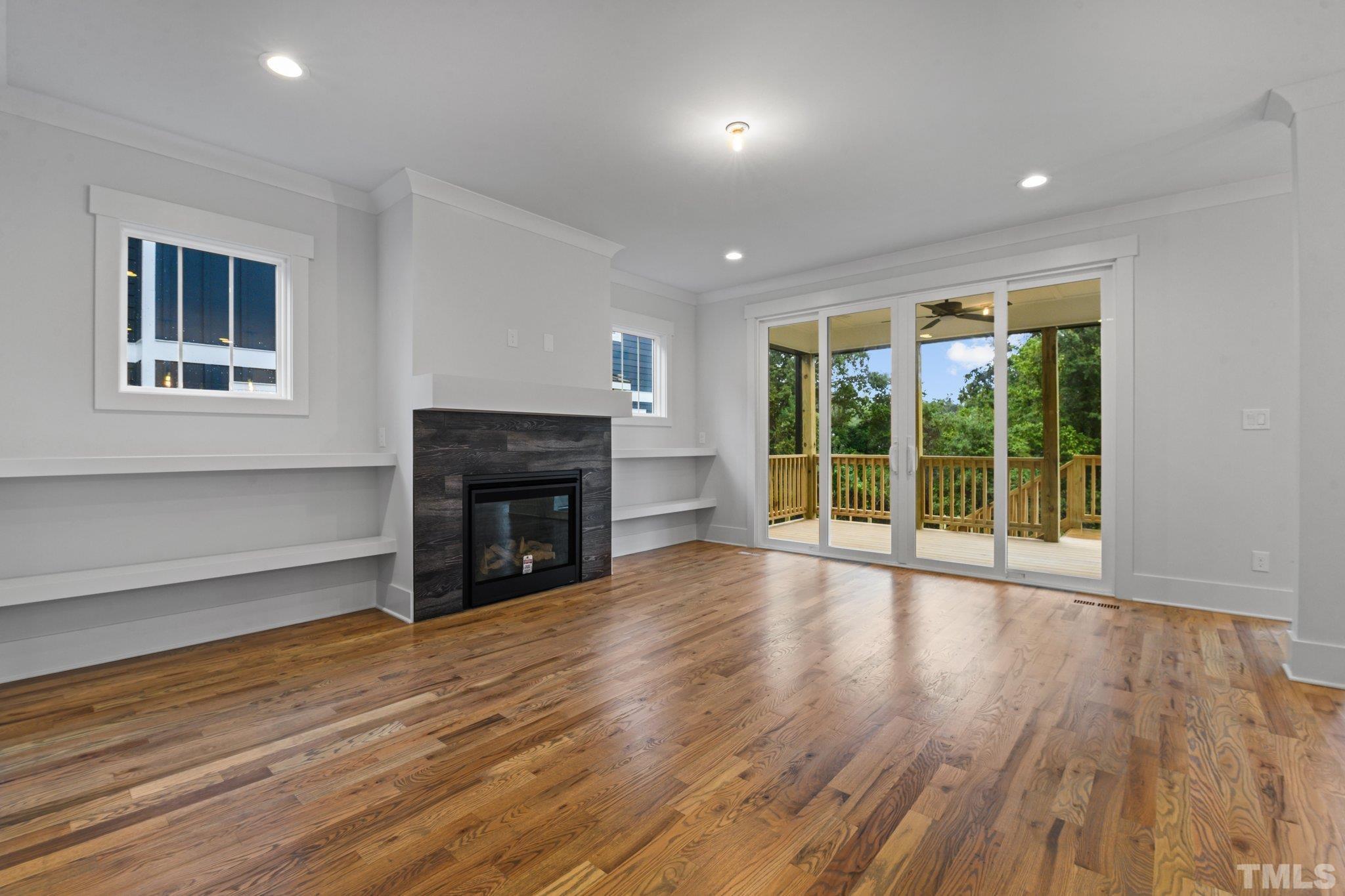 1019 Glascock Street Raleigh, NC 27610 - Photo 13 of 30 a view of empty room with wooden floor and fireplace