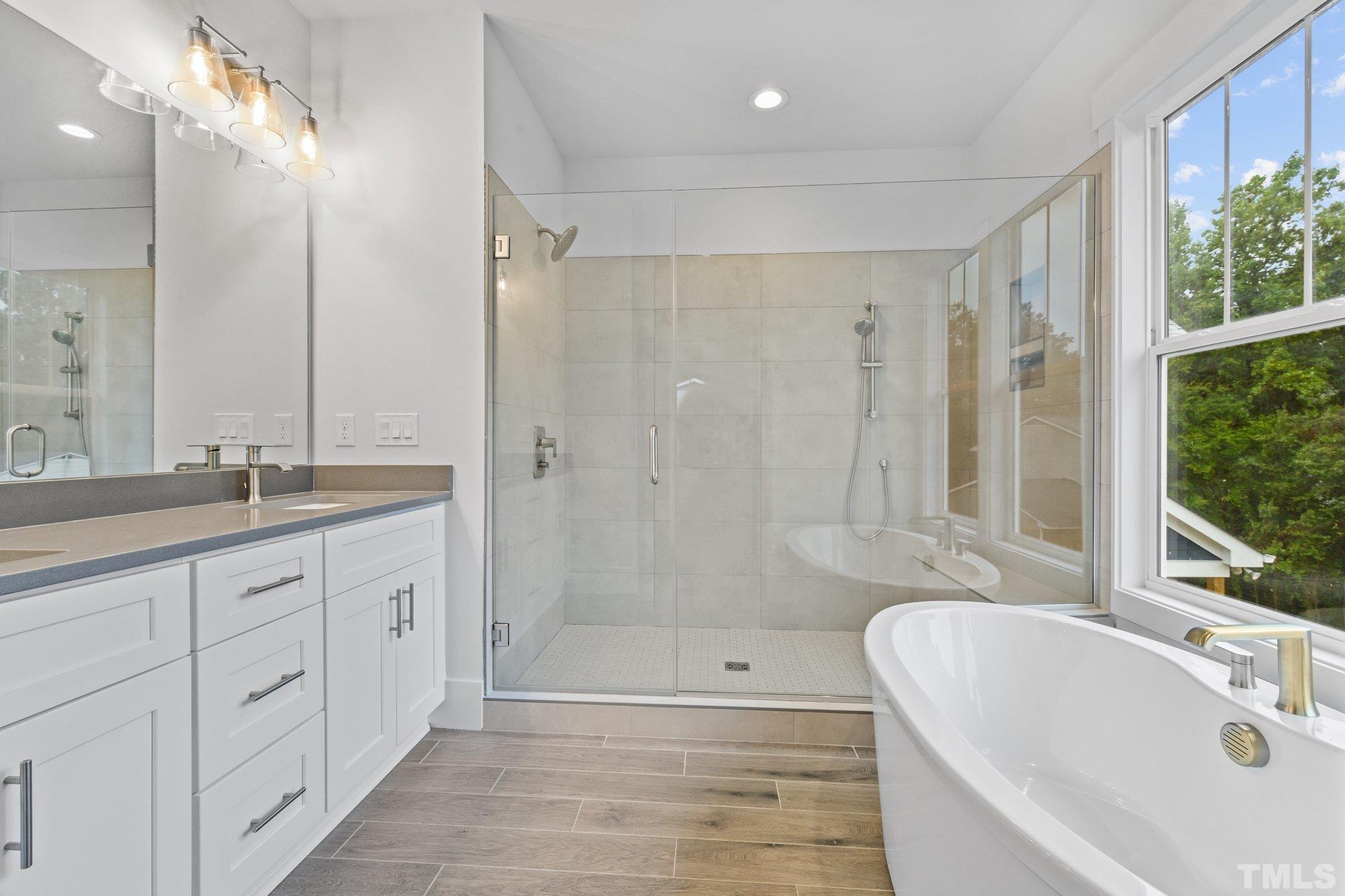 1019 Glascock Street Raleigh, NC 27610 - Photo 27 of 30 a bathroom with a tub sink shower and two mirror