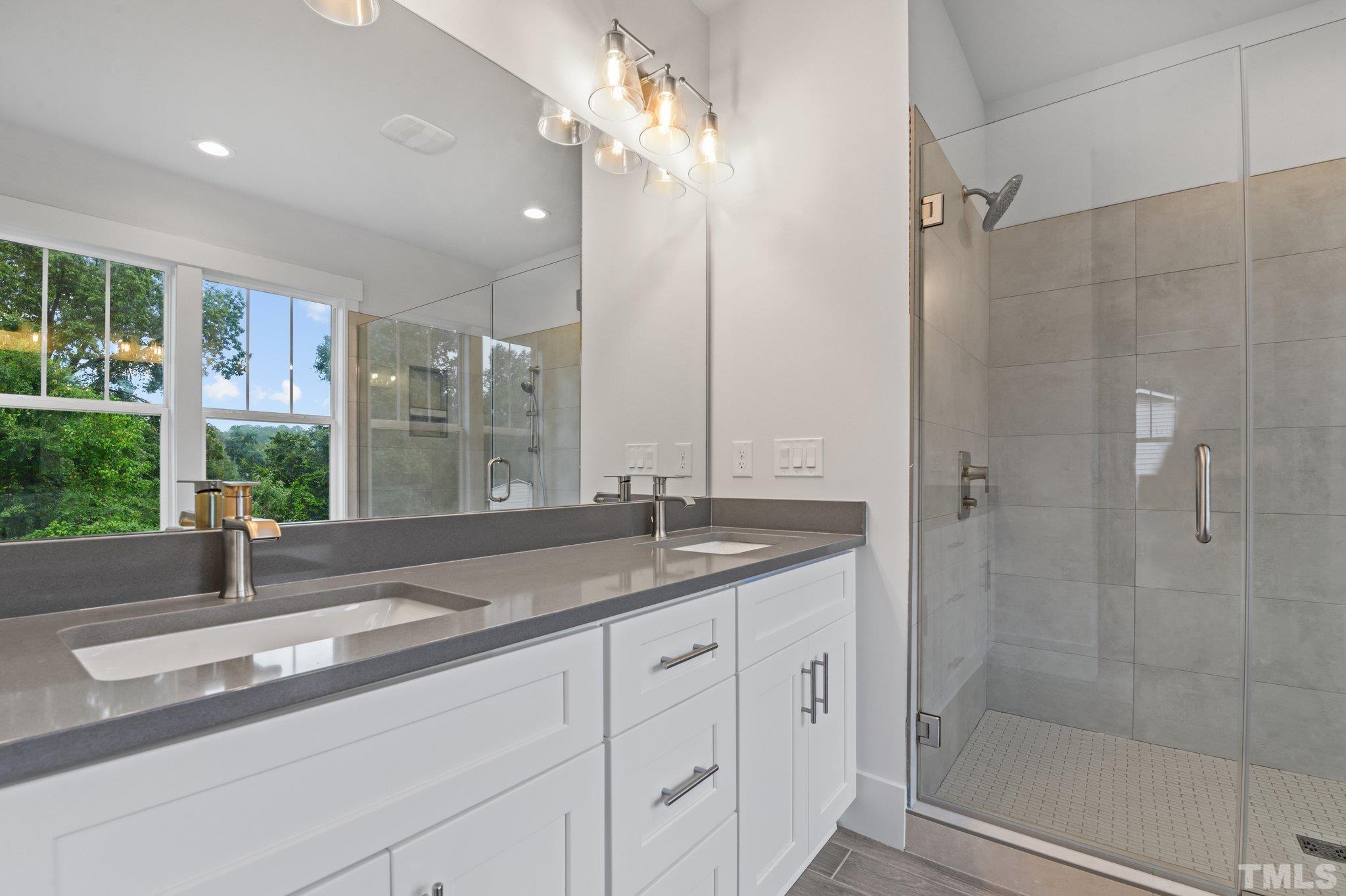 1019 Glascock Street Raleigh, NC 27610 - Photo 28 of 30 a bathroom with a granite countertop sink a mirror and a shower
