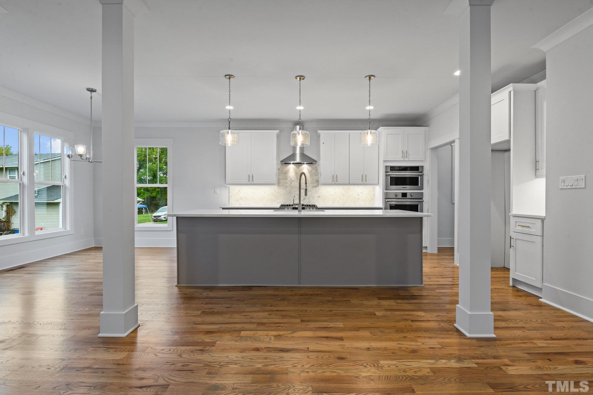 1019 Glascock Street Raleigh, NC 27610 - Photo 9 of 30 a large kitchen with stainless steel appliances kitchen island granite countertop a large counter top and wooden floors