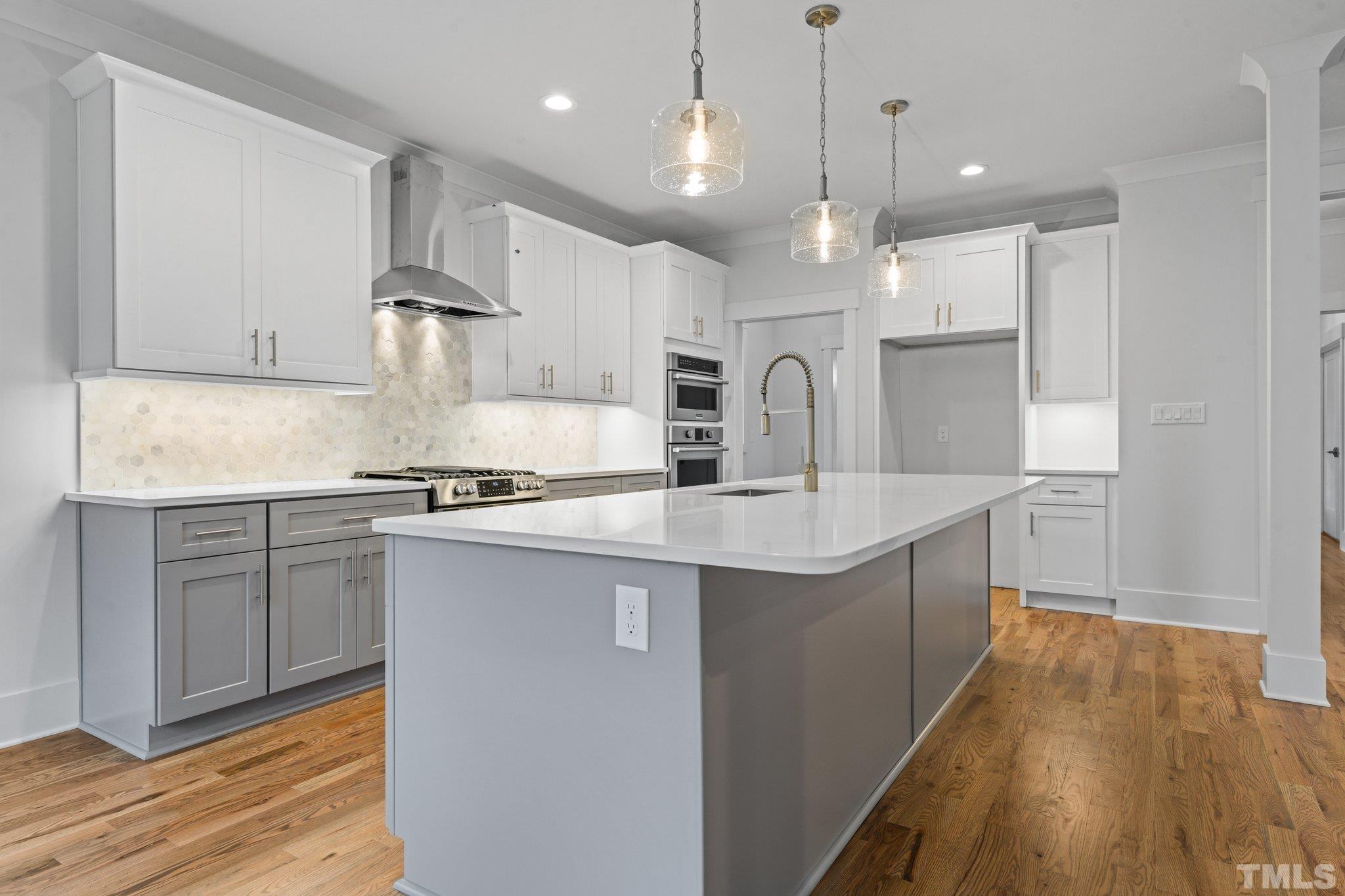 1019 Glascock Street Raleigh, NC 27610 - Photo 10 of 30 a kitchen with kitchen island a sink stainless steel appliances and cabinets