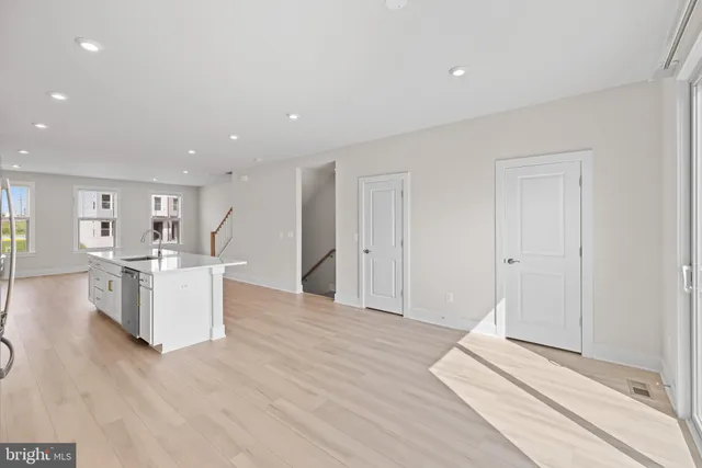 a kitchen with a refrigerator and a wooden floor