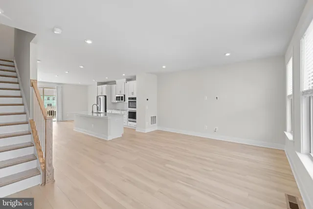 a view of a big room with wooden floor and windows