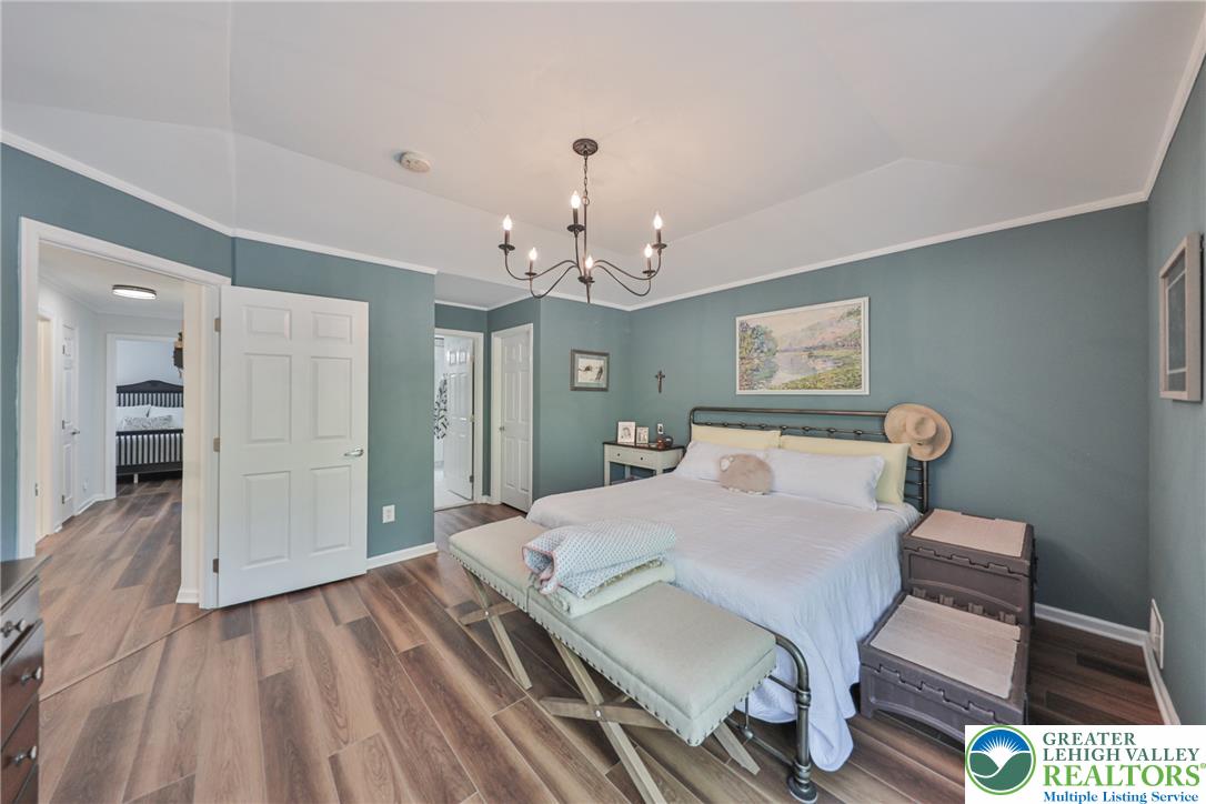 163 Muirfield Way Easton, PA 18042 - Photo 20 of 48 a bedroom with a bed and a chandelier