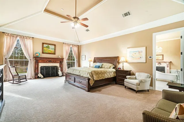 a bedroom with a bed couch and a large window