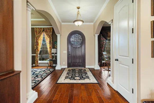 a front view of a house with wooden floor a rug and a large window