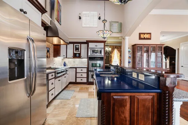 a kitchen with stainless steel appliances granite countertop a stove refrigerator and cabinets