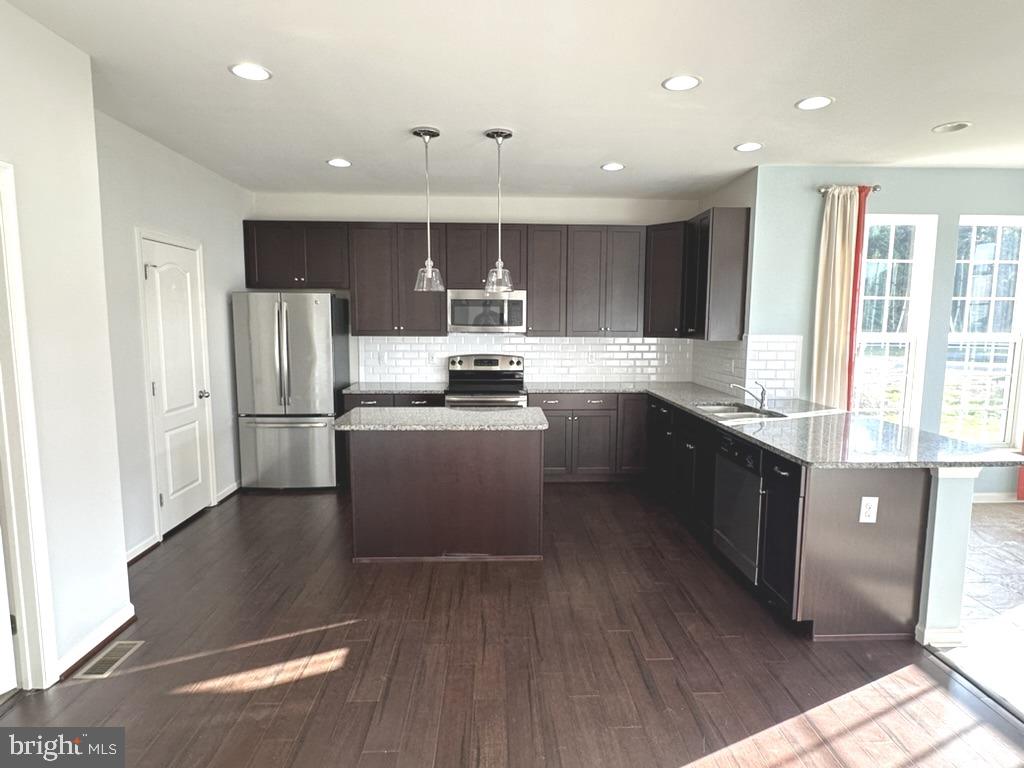 211 Arrowood Drive Smyrna, DE 19977 - Photo 8 of 22 a kitchen with stainless steel appliances granite countertop a refrigerator a sink dishwasher a stove and white countertops with wooden floor