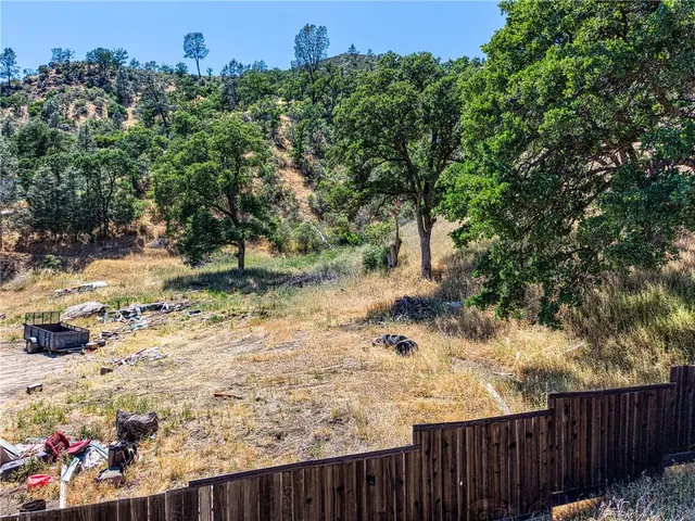 a view of a yard with wooden fence