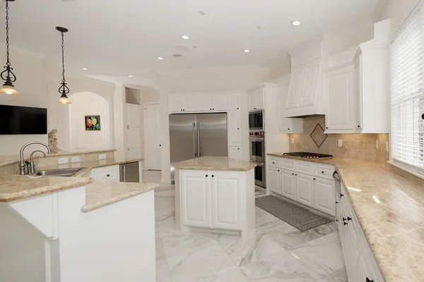 a kitchen with appliances a sink and cabinets