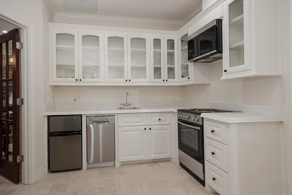 a kitchen with stainless steel appliances granite countertop white cabinets and a stove