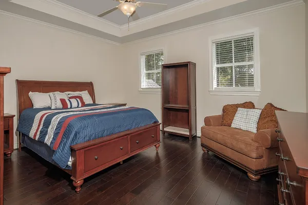 a bedroom with a bed and wooden floor