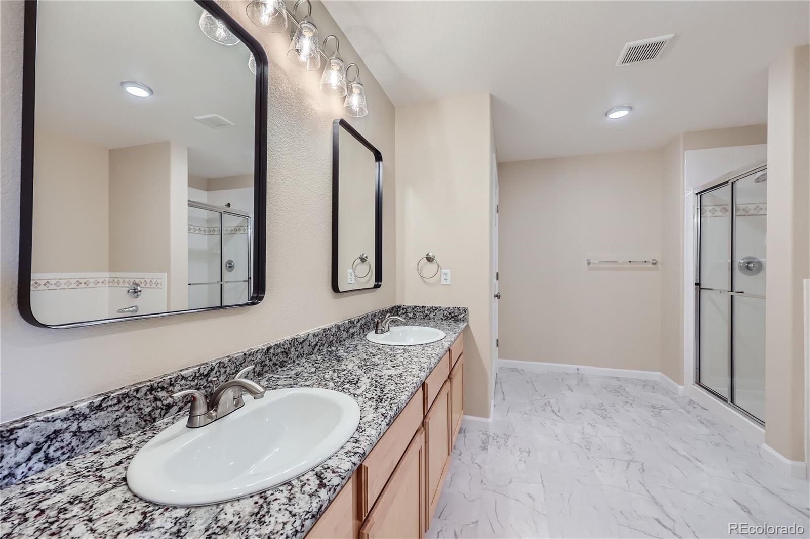 1515 Live Oak Road Castle Rock, CO 80104 - Photo 14 of 26 a bathroom with a granite countertop sink a mirror and a shower