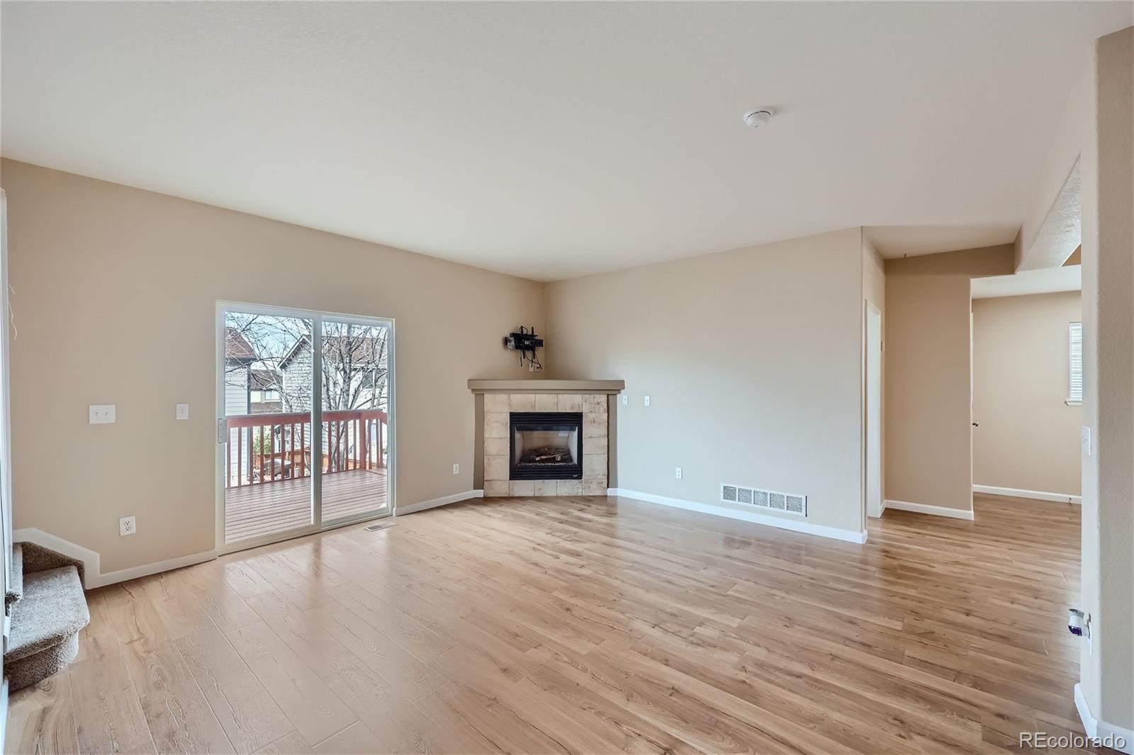 1515 Live Oak Road Castle Rock, CO 80104 - Photo 3 of 26 wooden floor fireplace and windows in an empty room