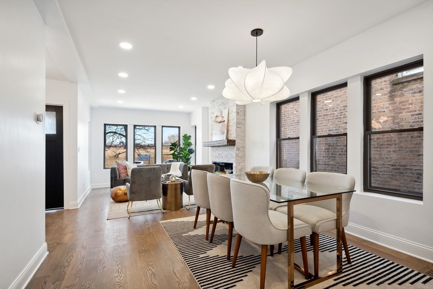 5426 North Western Avenue Chicago, IL 60625 - Photo 7 of 22 a dining room with wooden floor a chandelier a glass table and chairs