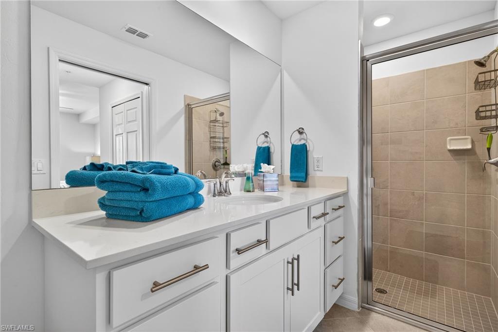 43985 Boardwalk Loop, Unit 2115 Punta Gorda, FL 33982 - Photo 13 of 28 a bathroom with a double vanity sink a mirror and shower