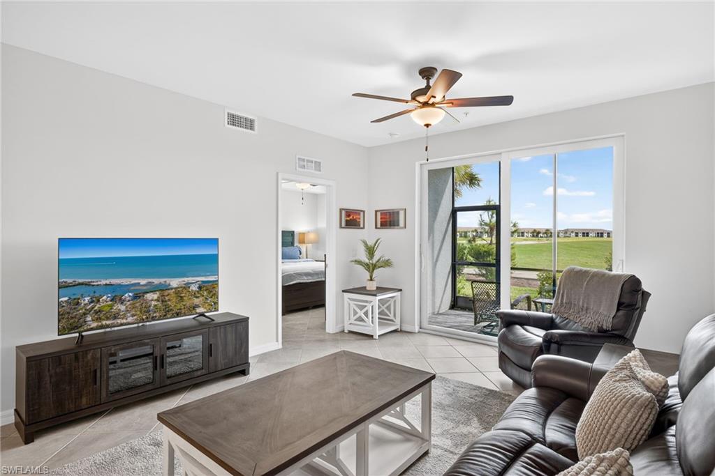 43985 Boardwalk Loop, Unit 2115 Punta Gorda, FL 33982 - Photo 7 of 28 a living room with furniture floor to ceiling window and a flat screen tv