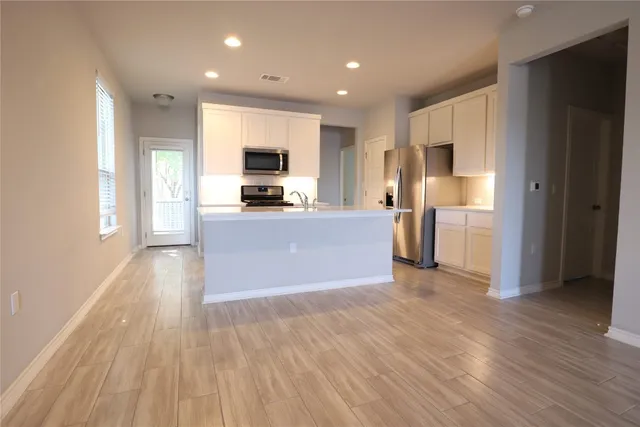 a view of a kitchen with a sink and a refrigerator