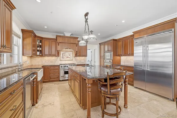 a kitchen with stainless steel appliances kitchen island granite countertop a stove refrigerator and cabinets