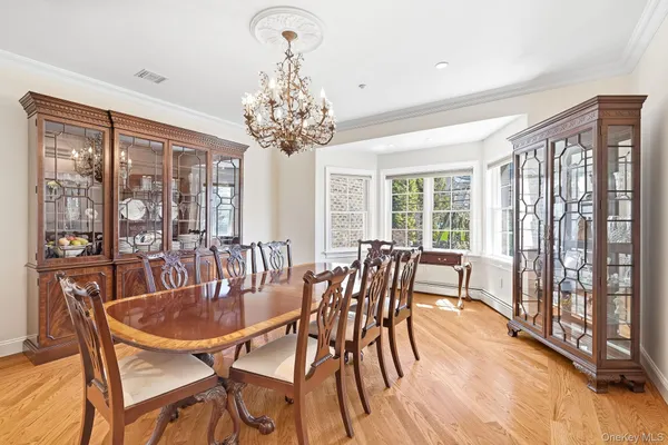 a dining room with furniture a chandelier and wooden floor