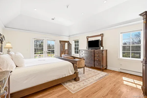 a bedroom with a bed flat screen tv and windows