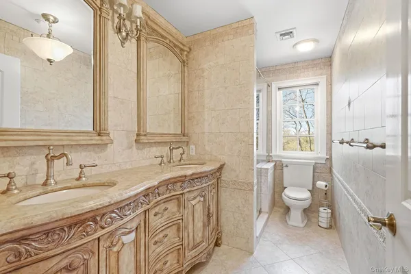 a bathroom with a granite countertop sink mirror vanity and toilet