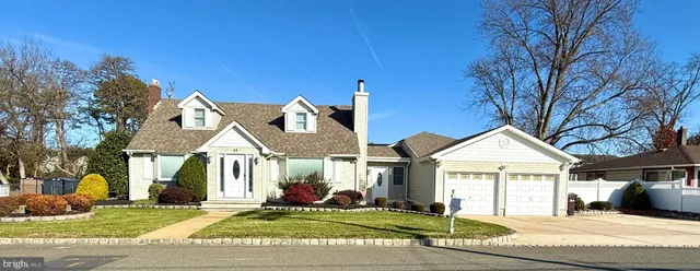 a view of a white house with a big yard and large trees