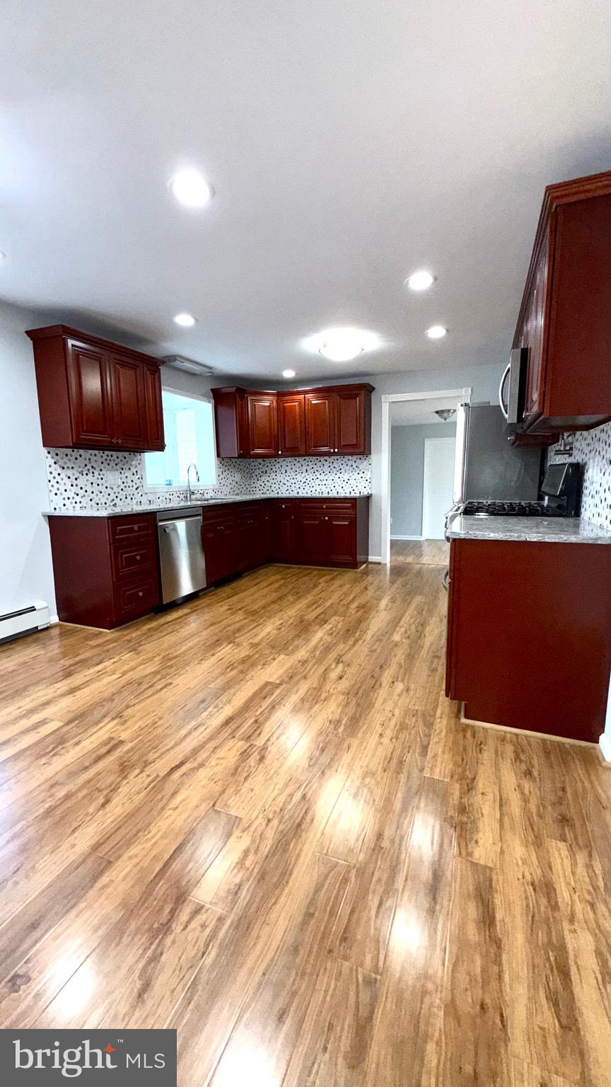 27 3rd Avenue Toms River, NJ 08757 - Photo 10 of 69 a view of a kitchen with kitchen island a sink wooden floor and a large window