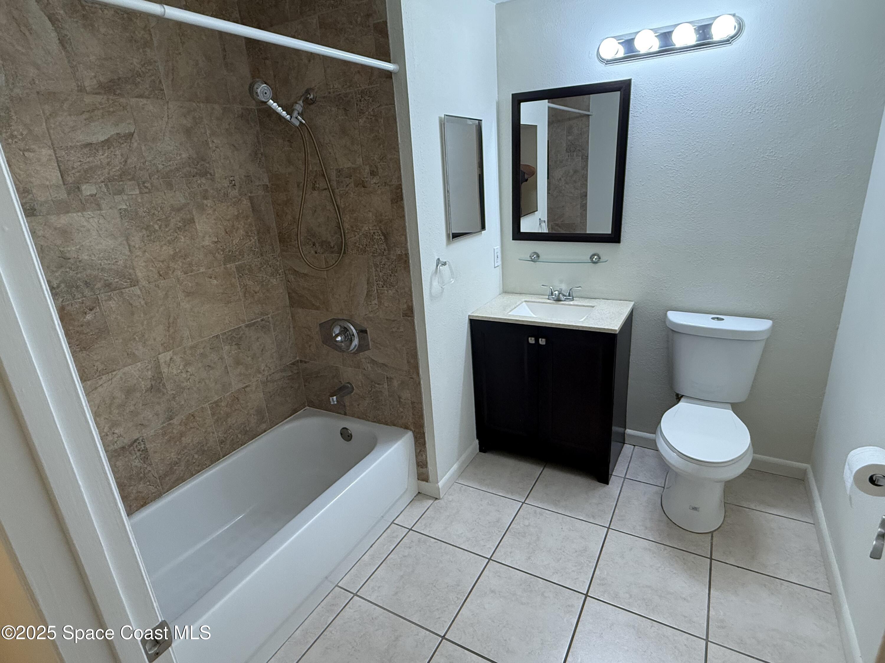 1790 Rocky Wood Circle, Unit 205 Rockledge, FL 32955 - Photo 11 of 11 a bathroom with a toilet sink and mirror