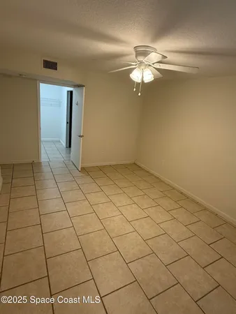 a view of a livingroom with an empty space and a ceiling fan