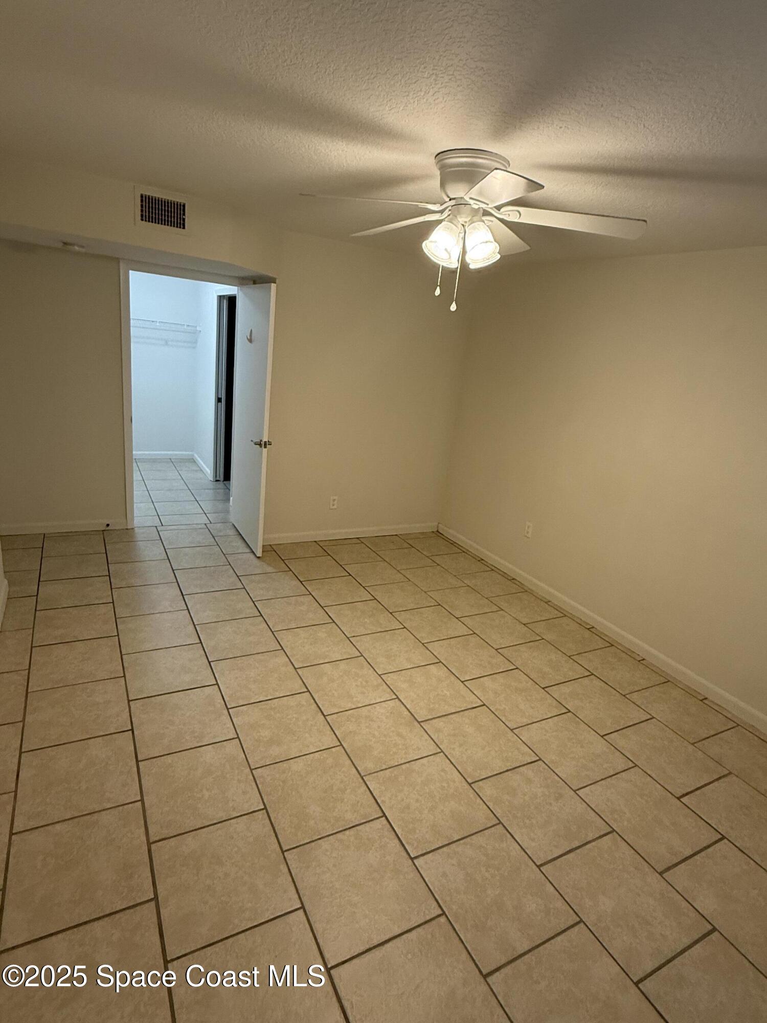 1790 Rocky Wood Circle, Unit 205 Rockledge, FL 32955 - Photo 9 of 11 a view of a livingroom with an empty space and a ceiling fan