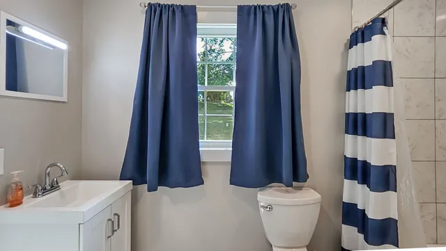 a bathroom with a toilet a sink and a mirror
