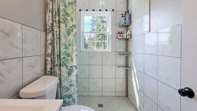 a bathroom with a toilet and shower