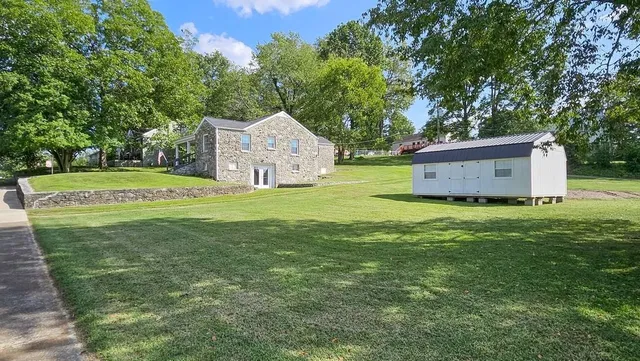 a front view of a house with a yard and trees