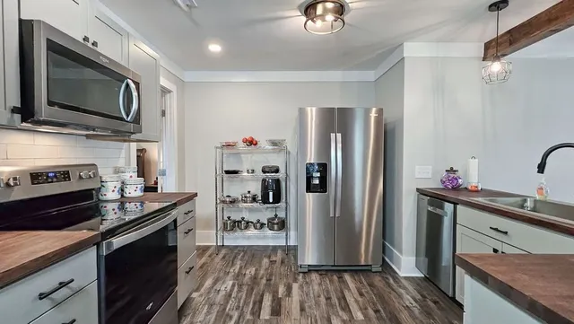 a kitchen with stainless steel appliances granite countertop a refrigerator a stove top oven a sink and dishwasher