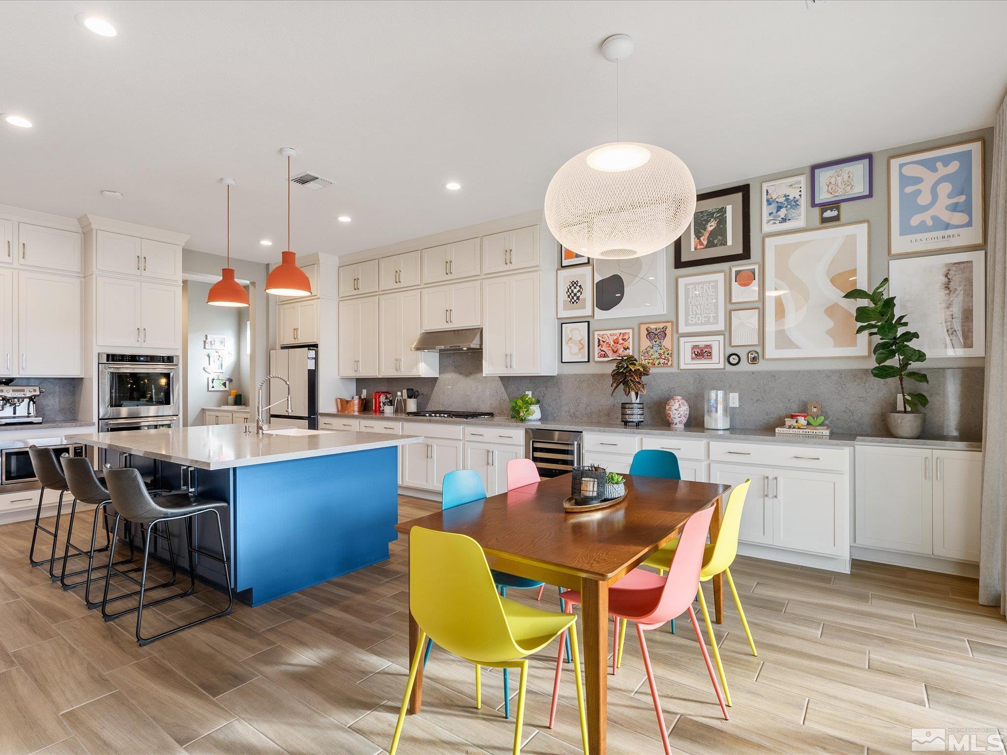 15033 Iron River Drive Reno, NV 89521 - Photo 17 of 39 a kitchen with stainless steel appliances granite countertop a stove a sink dishwasher a dining table and chairs with wooden floor