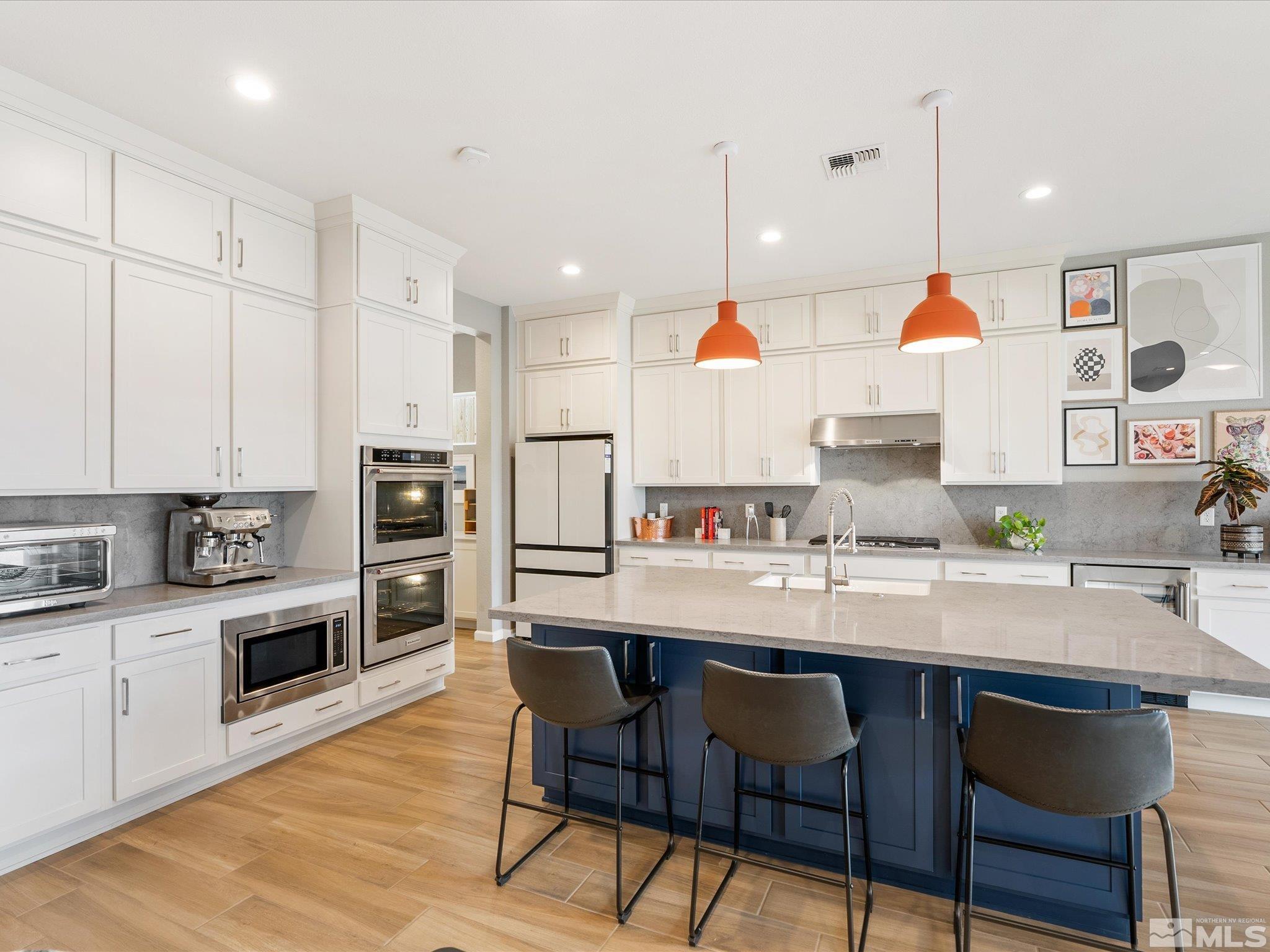 15033 Iron River Drive Reno, NV 89521 - Photo 23 of 39 a kitchen with stainless steel appliances granite countertop a sink a stove a refrigerator and chairs