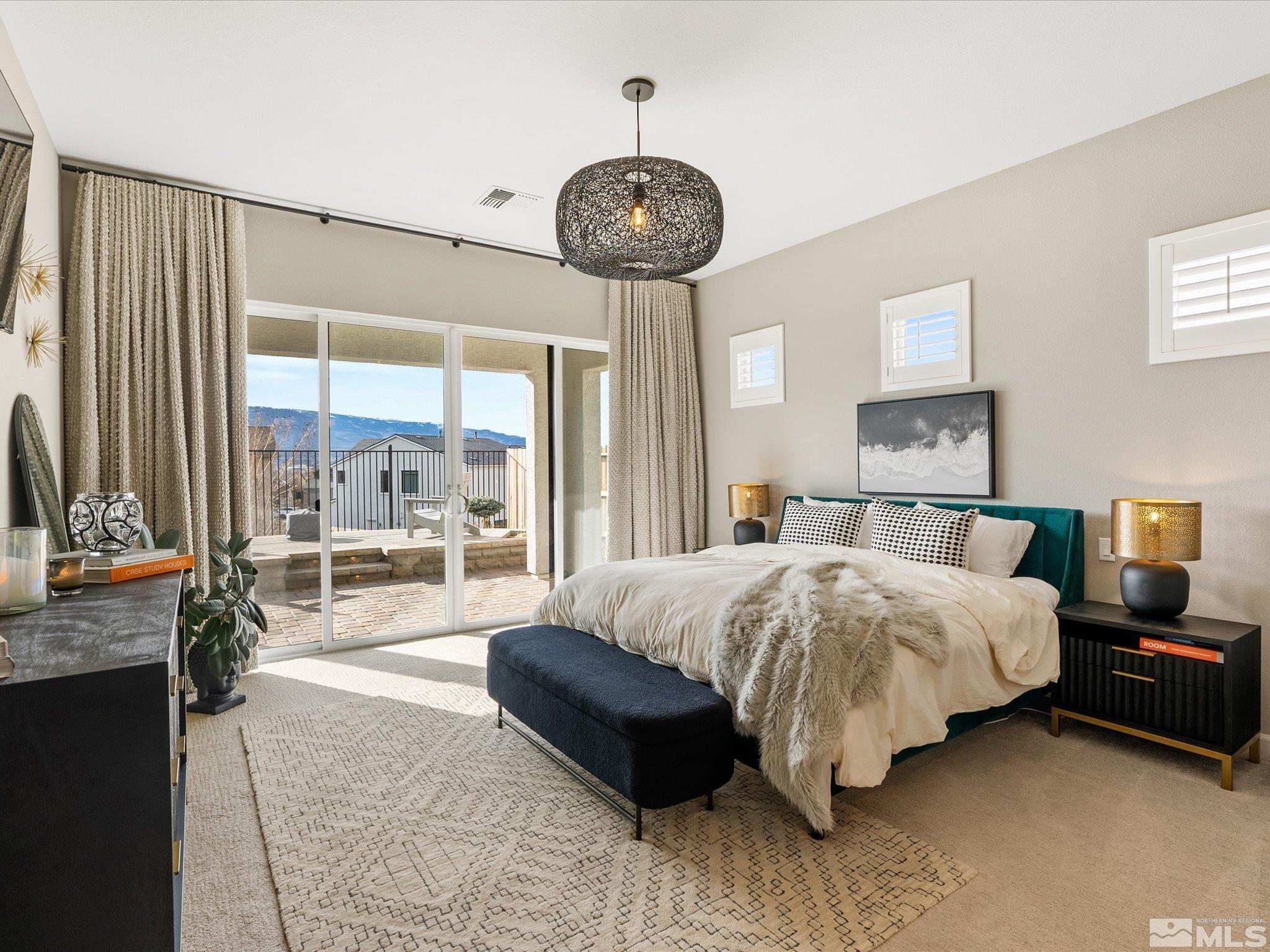 15033 Iron River Drive Reno, NV 89521 - Photo 24 of 39 a spacious bedroom with a bed a chandelier and a large window