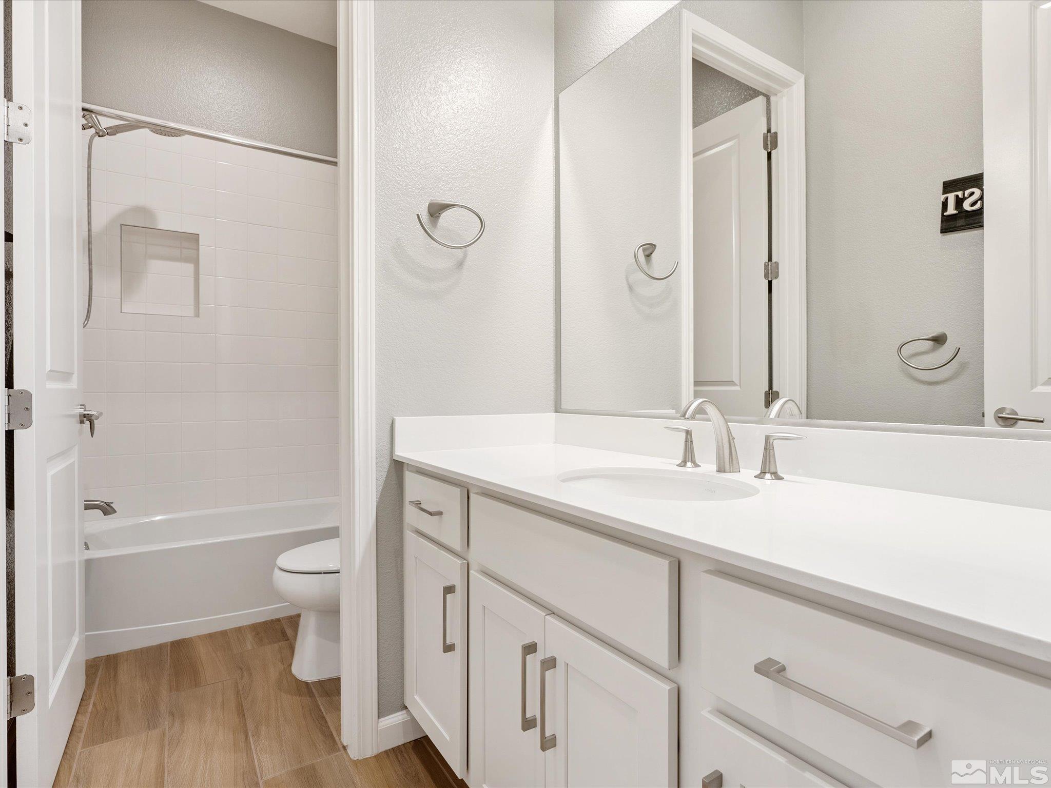 15033 Iron River Drive Reno, NV 89521 - Photo 34 of 39 a bathroom with a sink a toilet and a large mirror