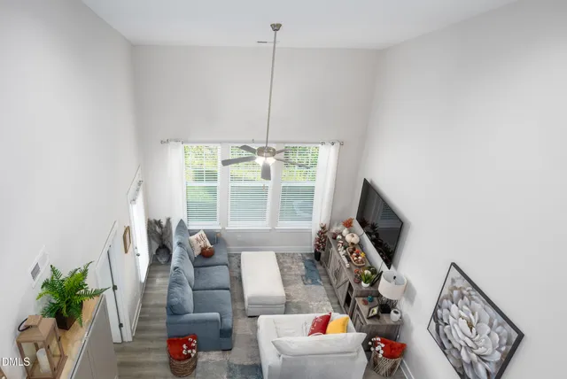 a living room with furniture a flat screen tv and a large window