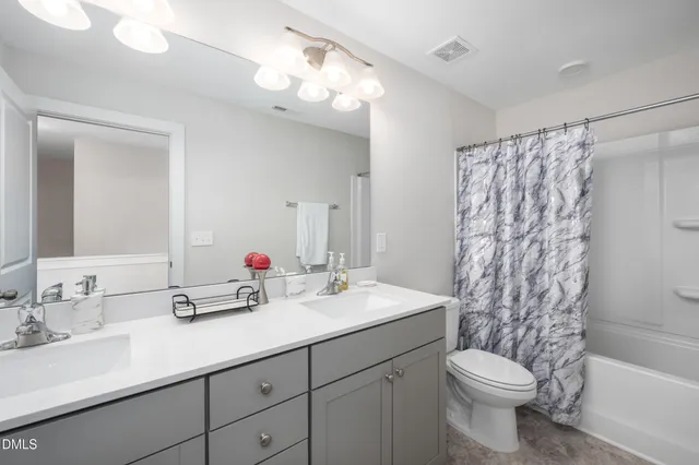 a bathroom with a double vanity sink mirror double and toilet