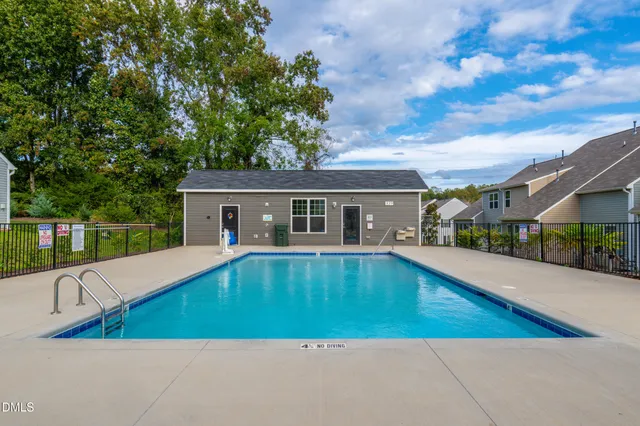 a view of house with swimming pool and sitting area