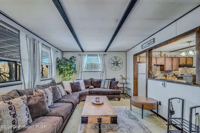 a kitchen with stainless steel appliances granite countertop a stove top oven a sink a dining table and chairs with wooden floor