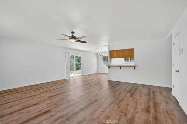 a view of a livingroom with wooden floor and a ceiling fan